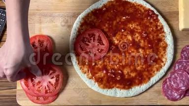 做<strong>披萨</strong>。 <strong>手工</strong>厨师把番茄片放在面团上。